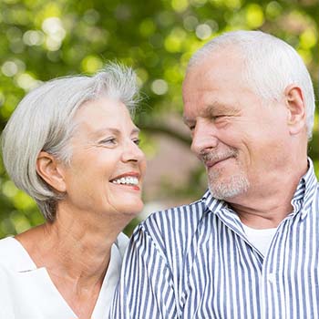 Older couple enjoying benefits of dental implants in Long Beach