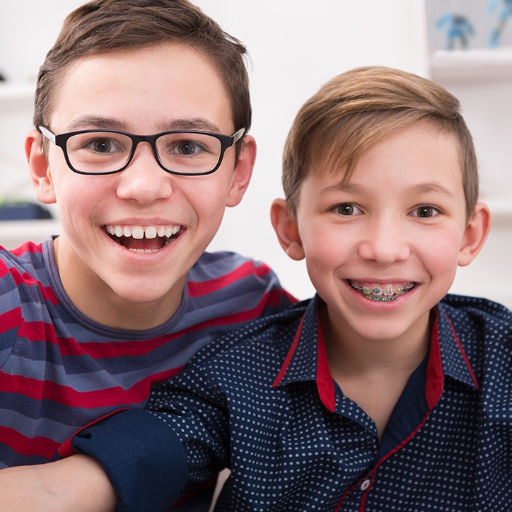 Teen smiling after braces next to younger boy with metal braces