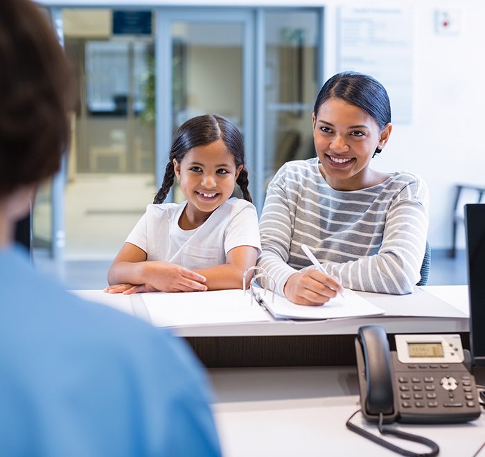 Mother and daughter checking in at dental office