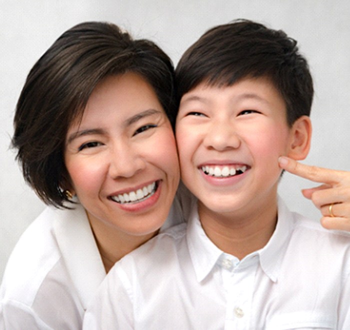 mom pointing at her son’s smile with dental sealants in Long Beach
