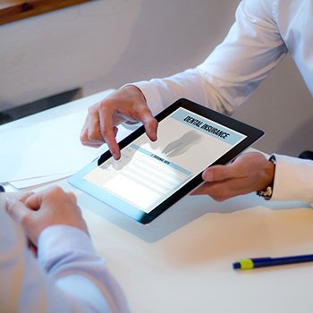 Showing patient a dental insurance form on a tablet