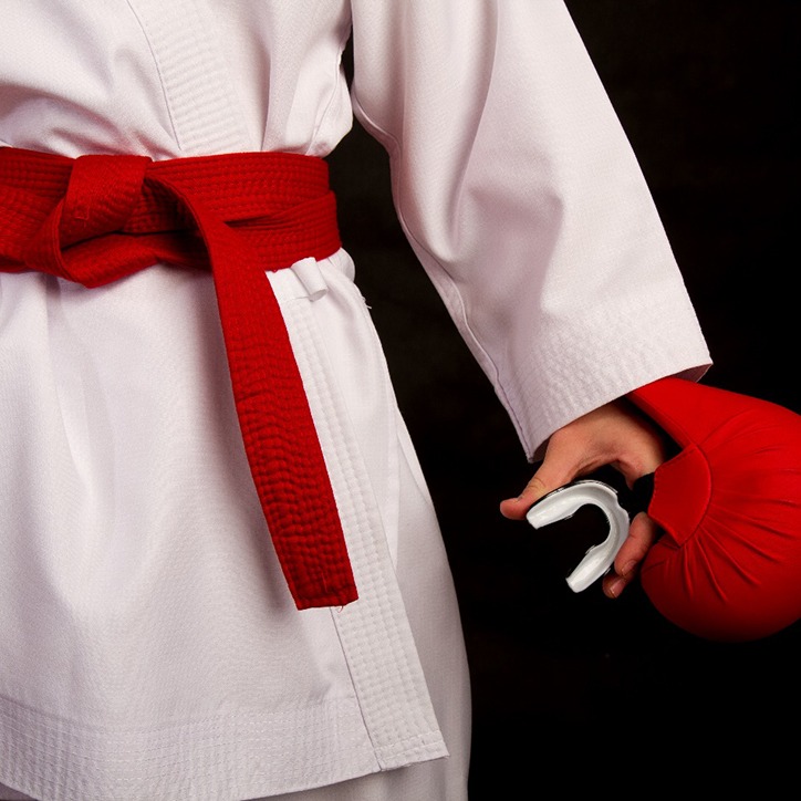 young child in gi holding a mouthguard 