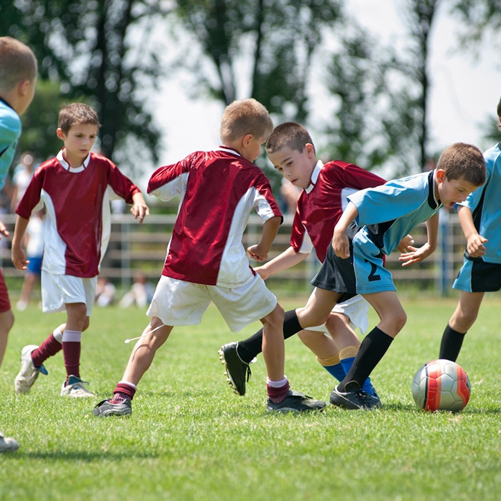 young children playing soccer 