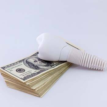 Implant on money representing the cost of dental implants in Long Beach