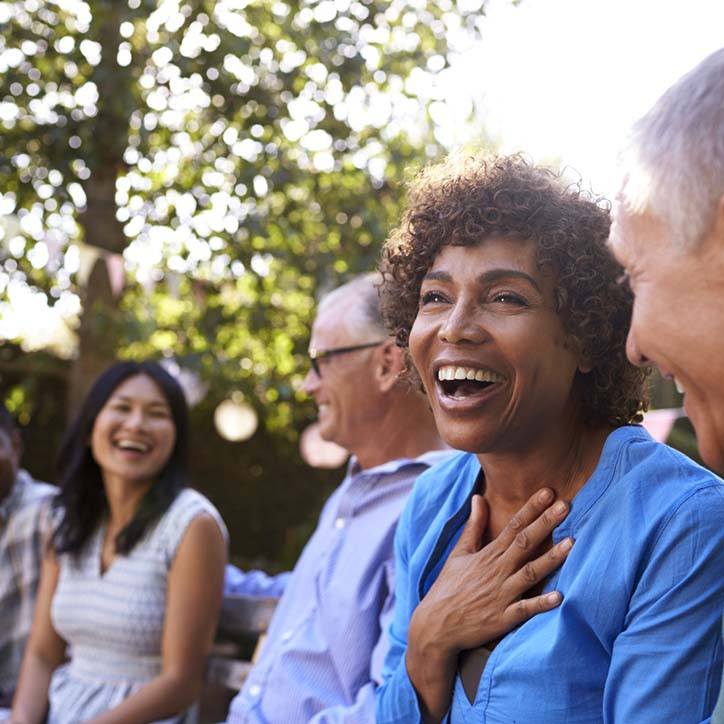 Diverse group of friends with dental implants in Long Beach laughing outside