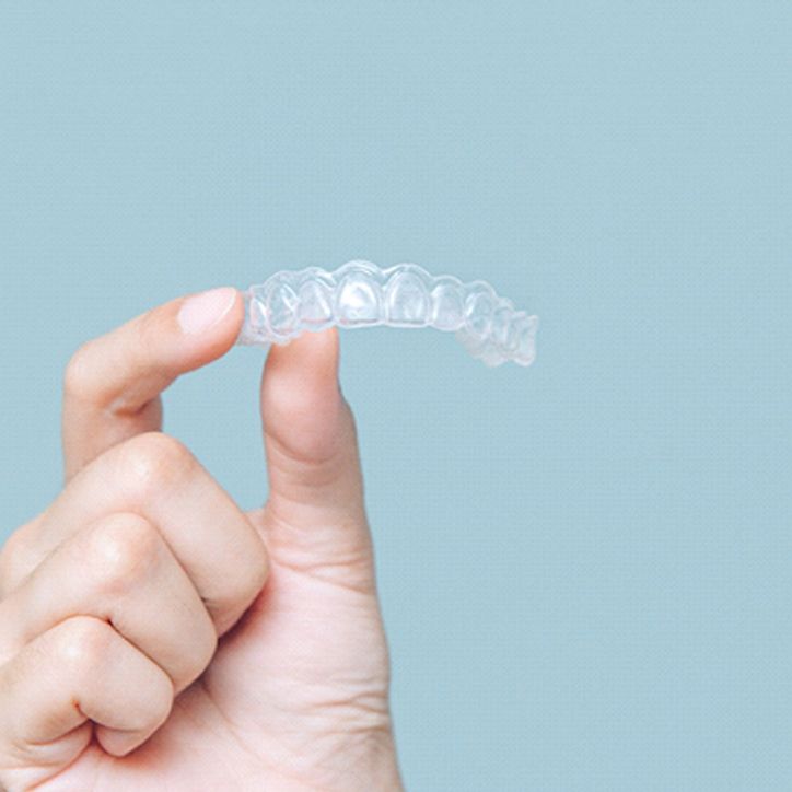 Patient holding up Invisalign tray