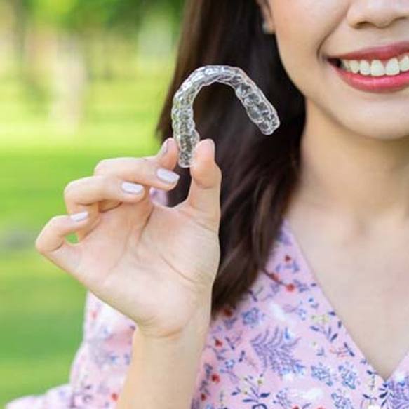 Smiling patient outside with Invisalign in Long Beach