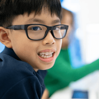 a child showing their attachments for Invisalign First treatment