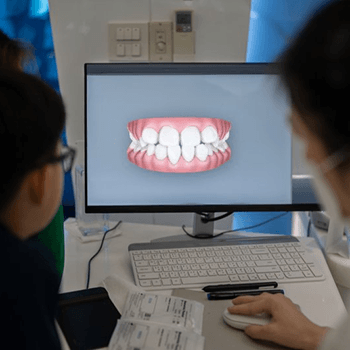 a dentist showing an Invisalign First patient their digital impressions