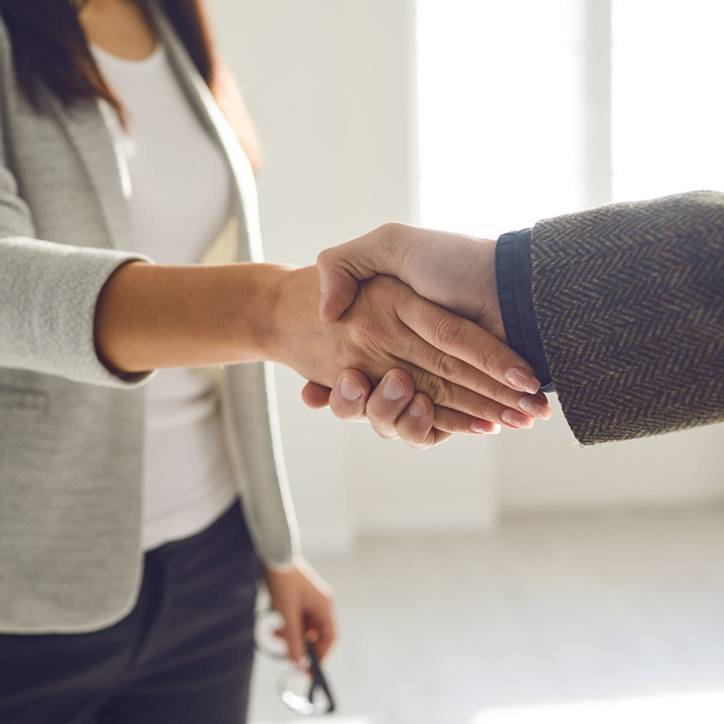 Woman and man shaking hands in a professional setting