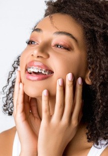 a woman smiling while wearing traditional braces