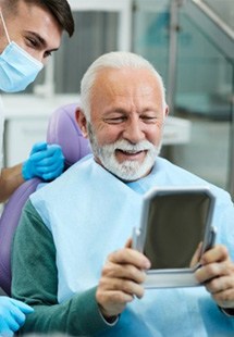 a patient checking his newly rebuilt smile