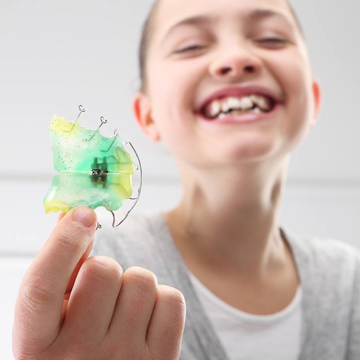 Laughing girl holding a retainer