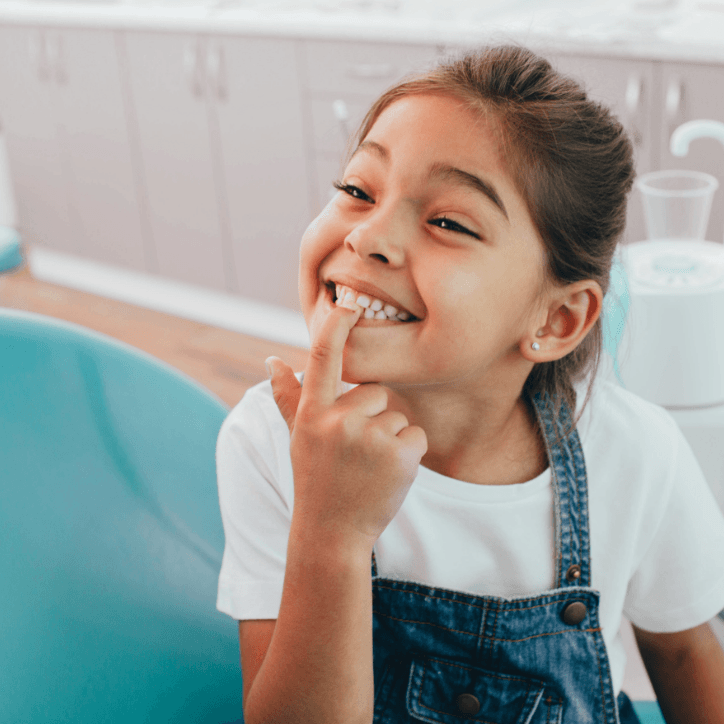 Child pointing to her smile after silver diamine fluoride treatment