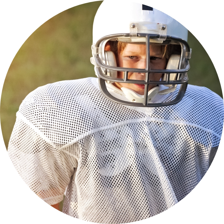 Preteen boy wearing football gear and athletic mouthguard