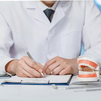 A dentist and patient discussing treatment in an office