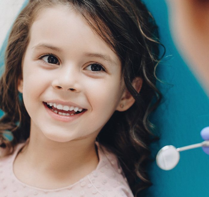 smiling little girl in a dentist’s chair