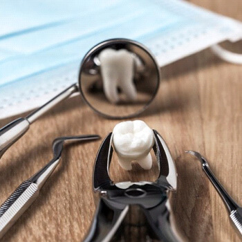 an extracted molar on a table with dental tools
