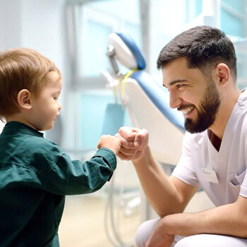 A dentist ancd child giving each other a first bump