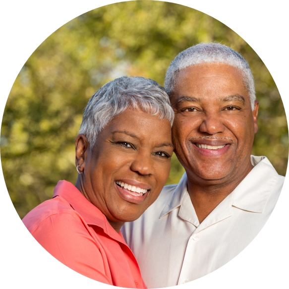 Older man and woman smiling after restorative dentistry visit