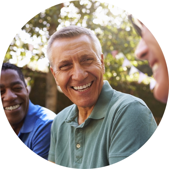 Older man smiling after replacing missing teeth