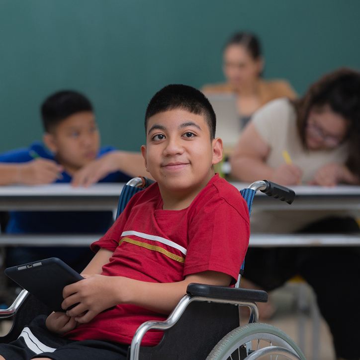 child with special needs smiling in a classroom 