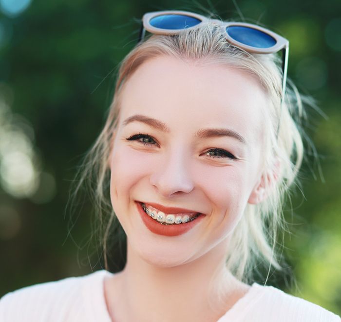 Teenage girl with sunglasses on head wearing braces in Long Beach, NY