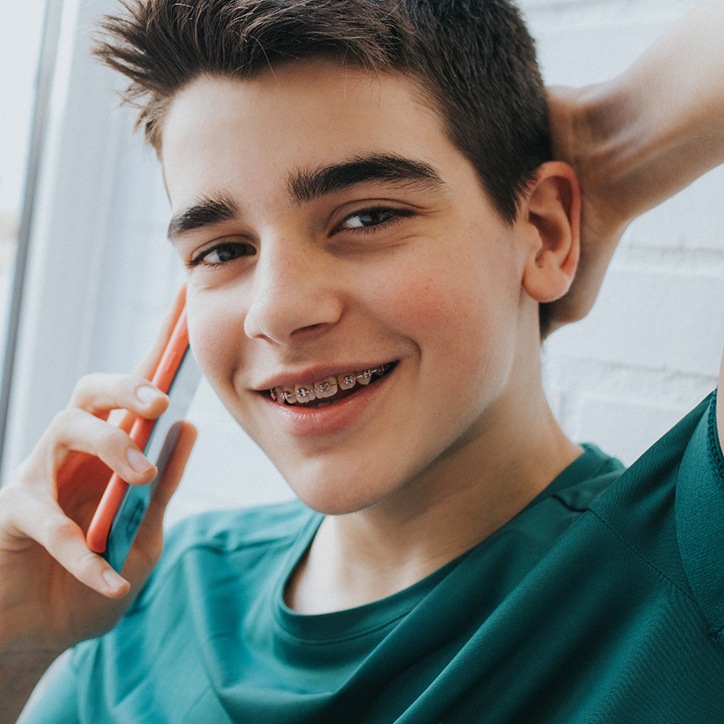 Teenage boy with braces in Long Beach, NY talking on phone