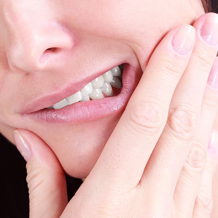 Patient in need of tooth extraction holding jaw