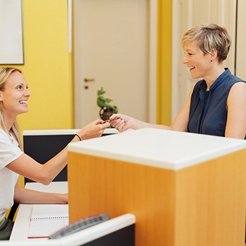 A woman paying the cost of teeth whitening 