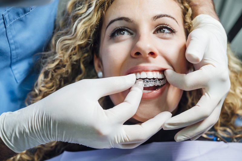 A dentist helping a patient avoid cavities during Invisalign.