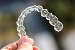 Closeup of Invisalign in Long Beach on colorful outdoor background