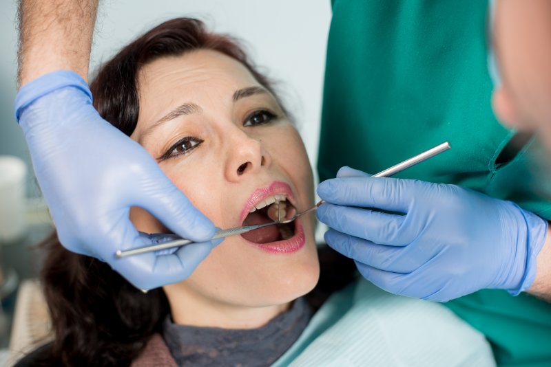 dentist looking inside a patient’s mouth