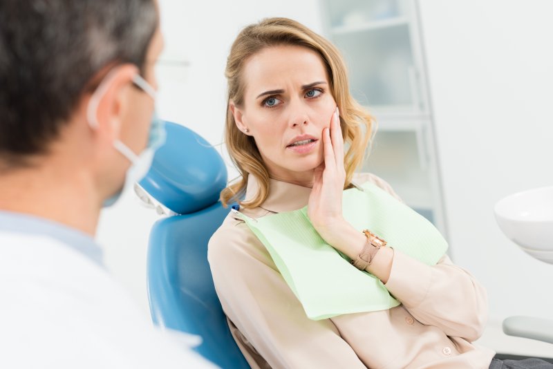 woman dealing with tooth pain at the dentist’s office