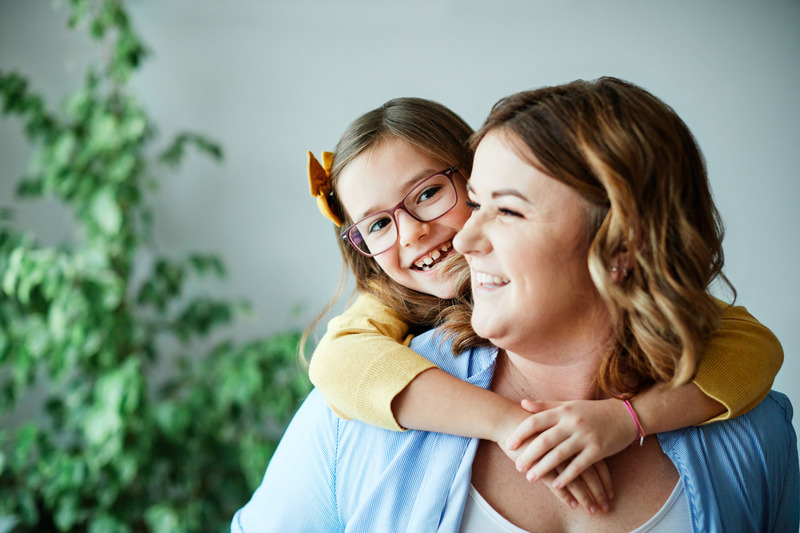 Child and parent smiling after tooth extractions