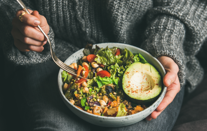 Woman's hands holding salad/grain bowl