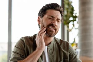 Man with a beard experiencing dental implant sensitivity